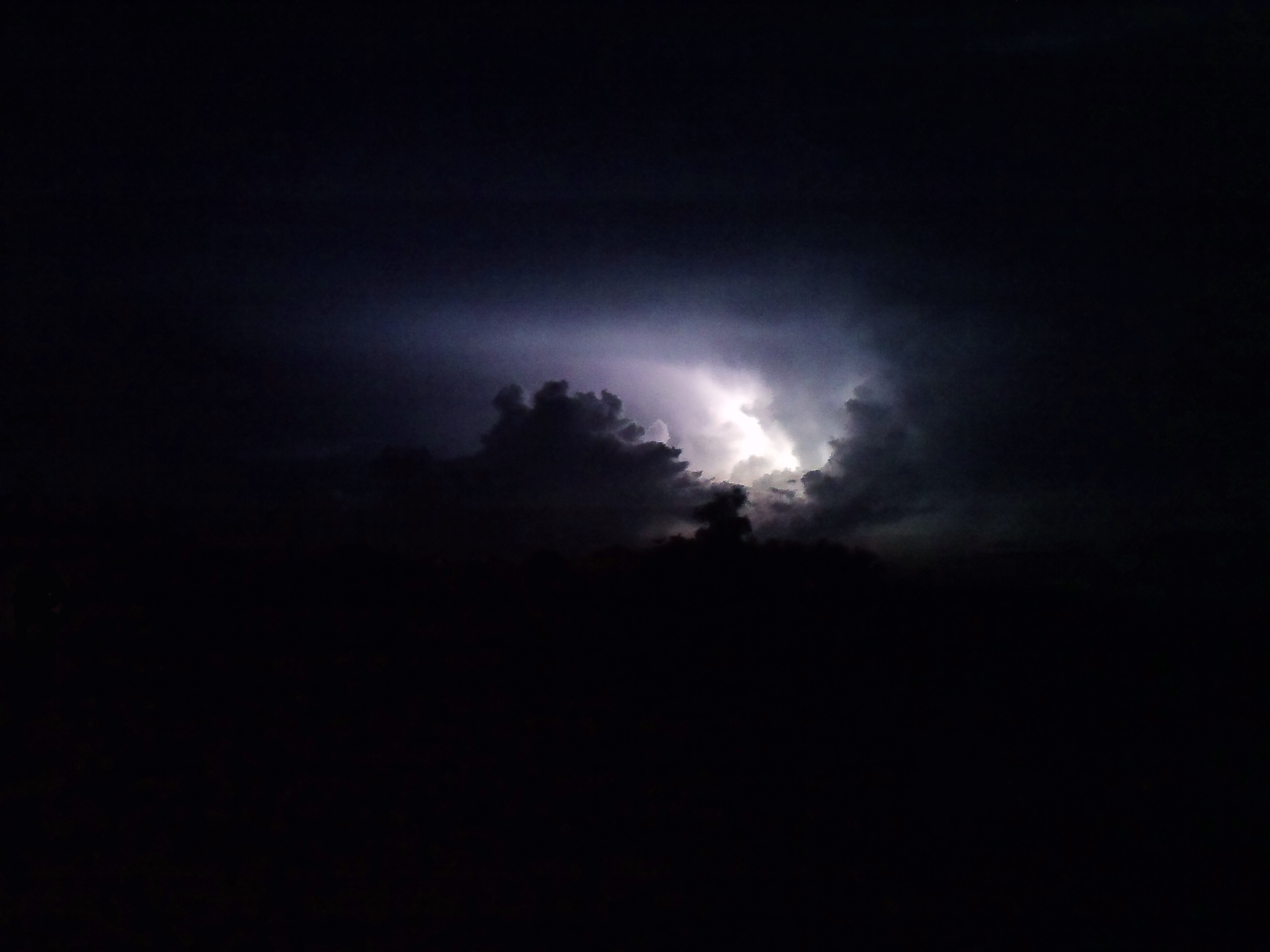 Lightning behind clouds